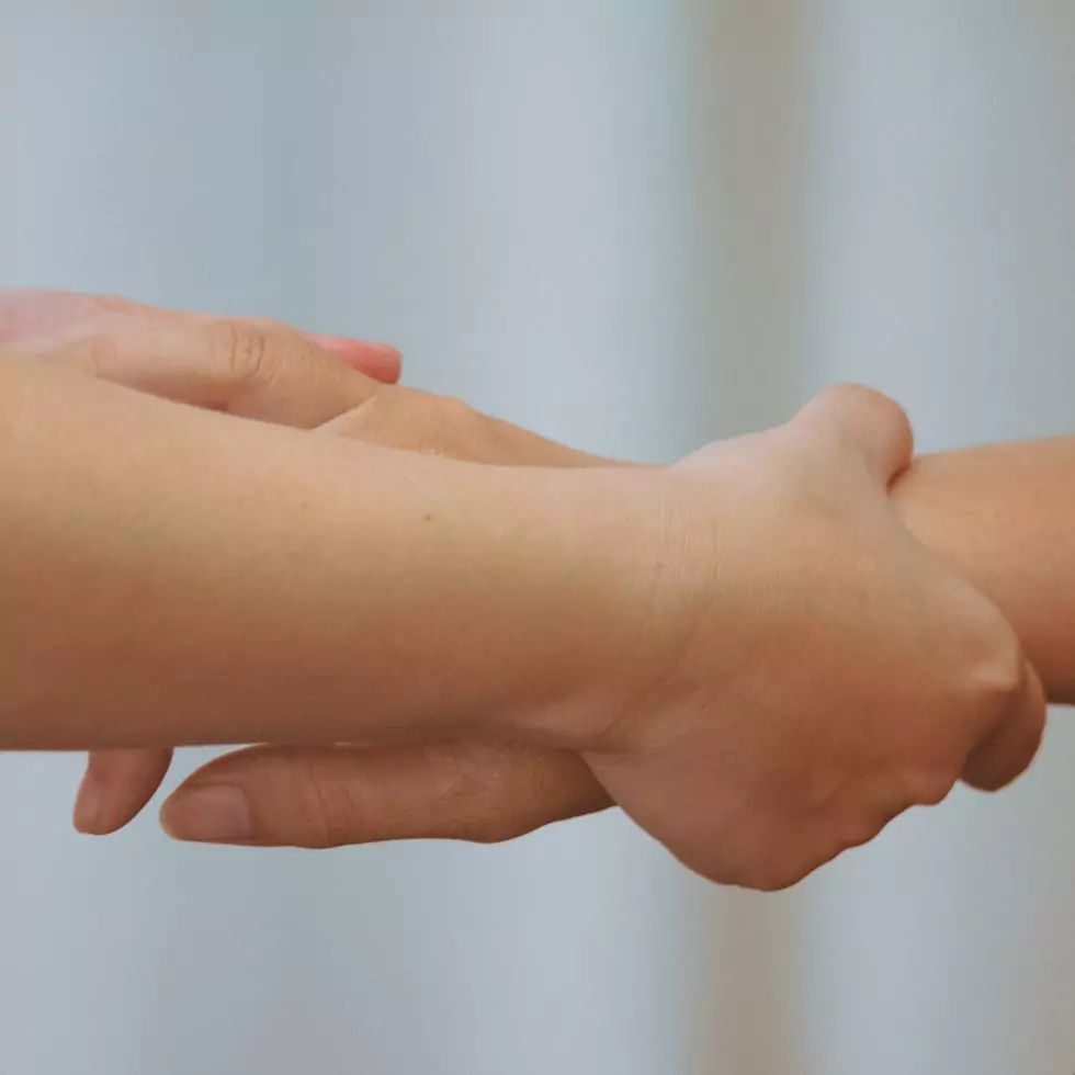 Lymphdrainage Therapeut massiert die Hand und den Arm einer Patientin