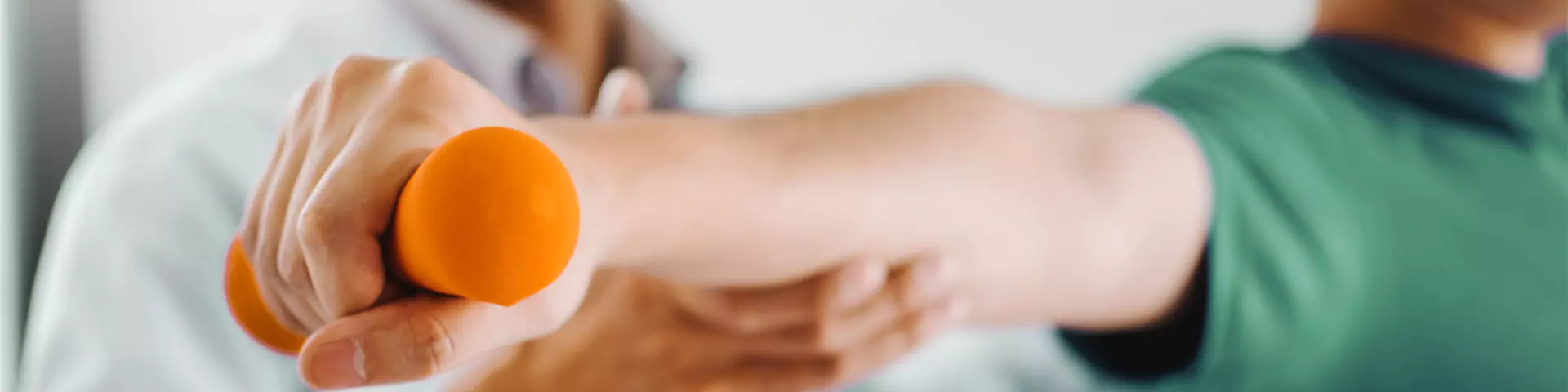 Hantelübung Physiotherapeut, der einen Patienten bei der Bewegung mit einer Hanteln unterstützt.